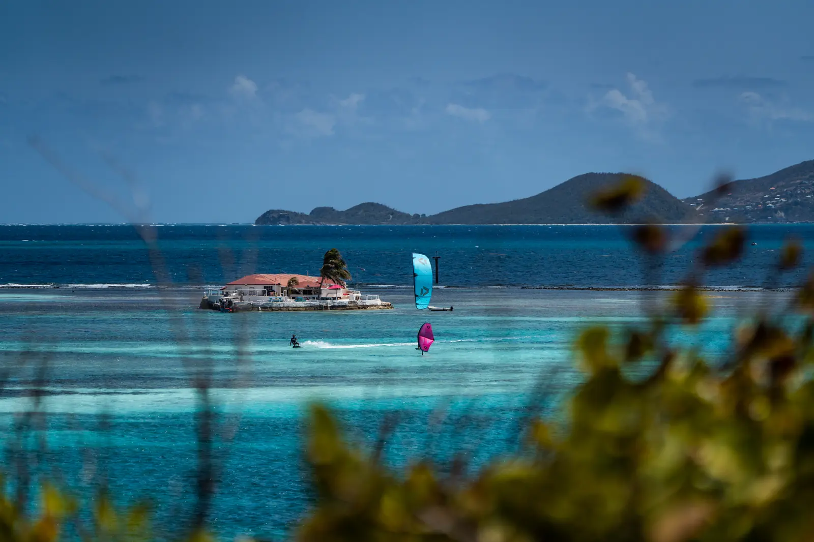 Kite and wing riders practicing in clear Union Island water